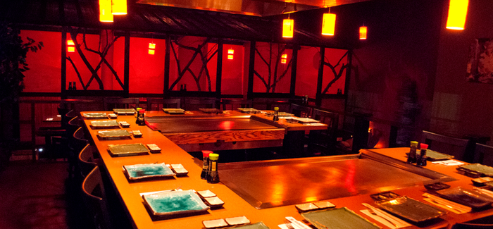 an empty hibachi restaurant with place settings around hibachi grills
